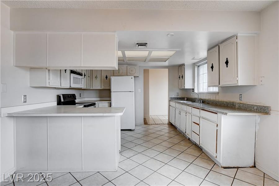 Starter-home kitchen with white cabinets, sold by Park Place Realty, Las Vegas